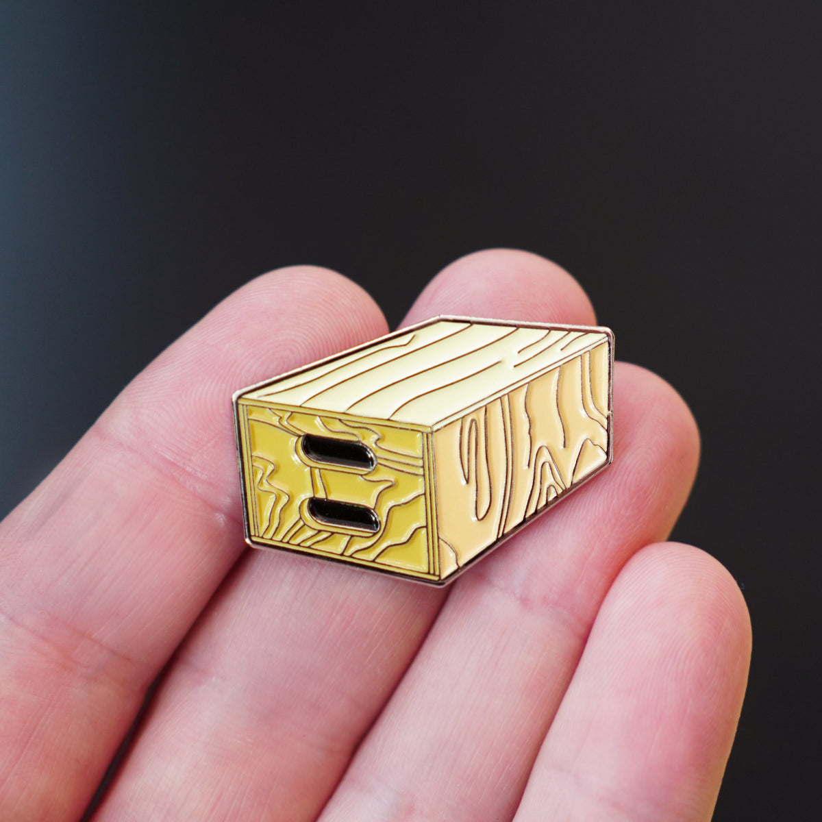 Apple Box Enamel Pin in hand