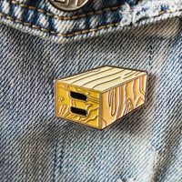 Apple Box Enamel Pin on a jacket