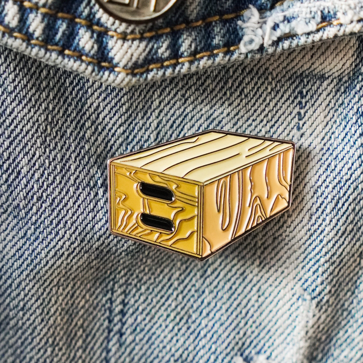 Apple Box Enamel Pin on a jacket