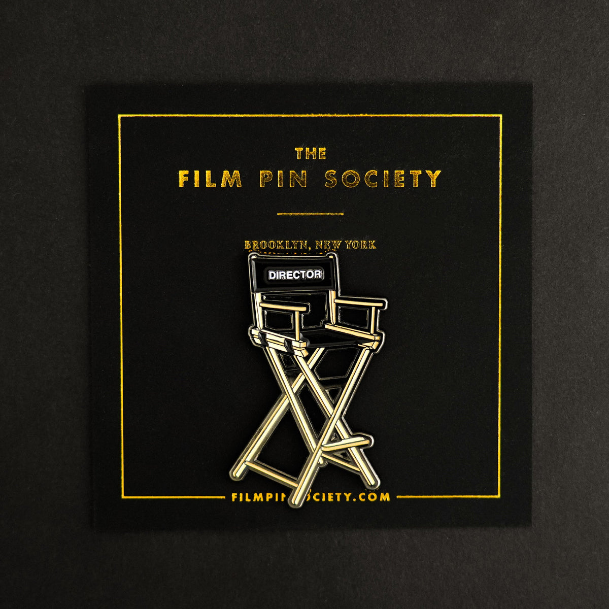 Director's Chair Enamel Pin on backing card