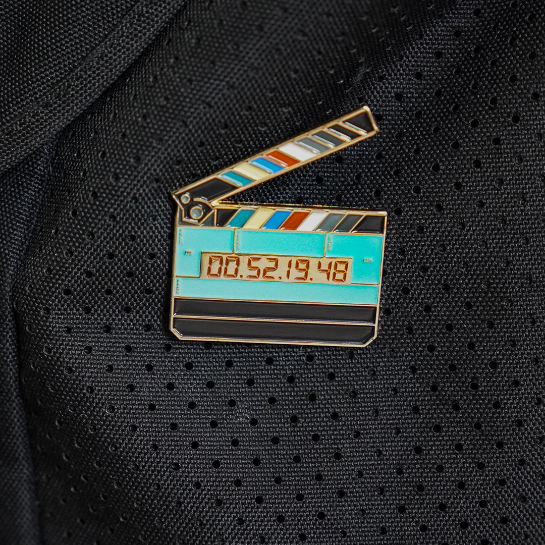 Jumbo Timecode Slate Enamel Pin on a bag