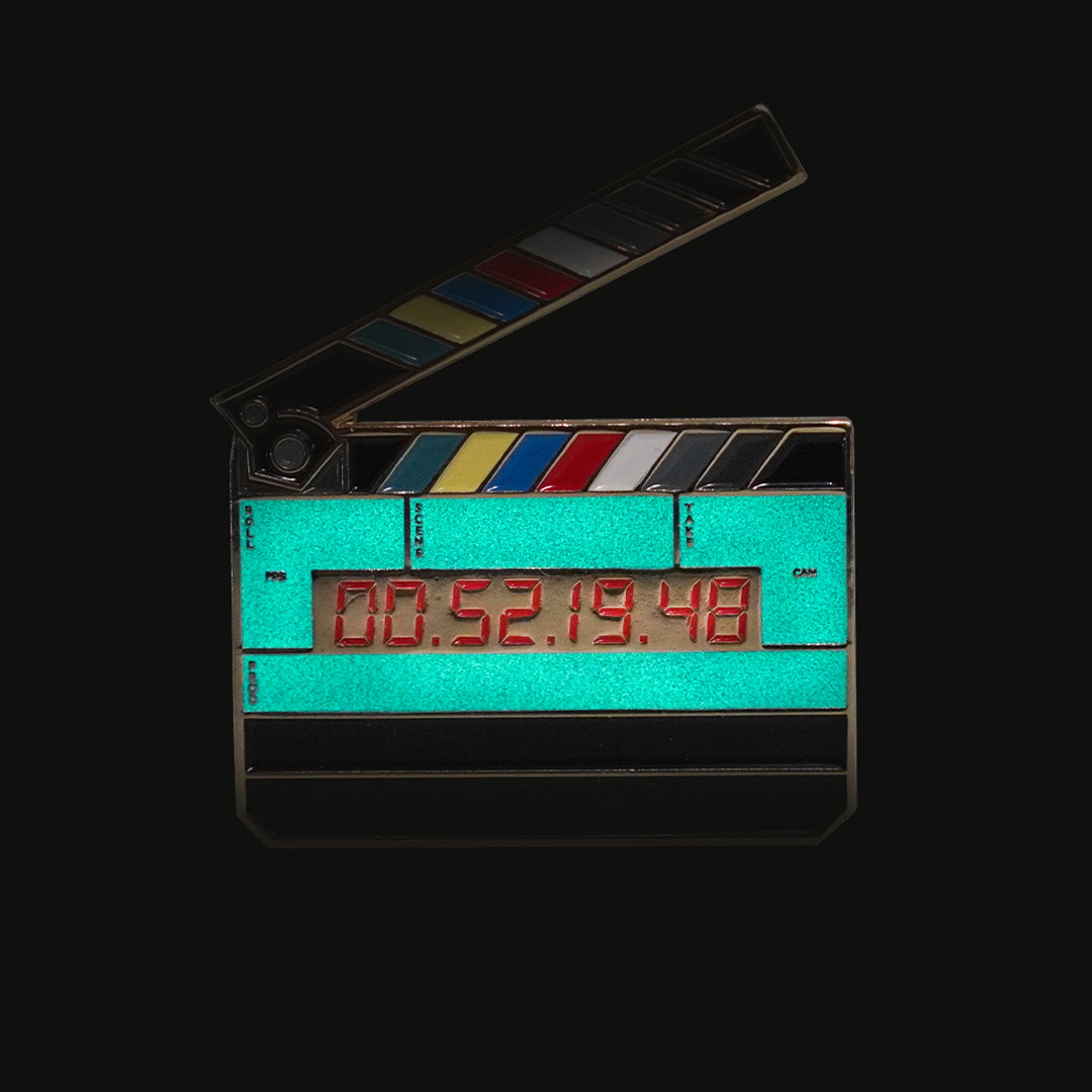 Jumbo Timecode Slate Enamel Pin glowing in the dark