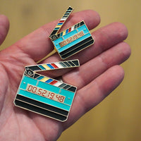 Jumbo Timecode Slate Enamel Pin in hand
