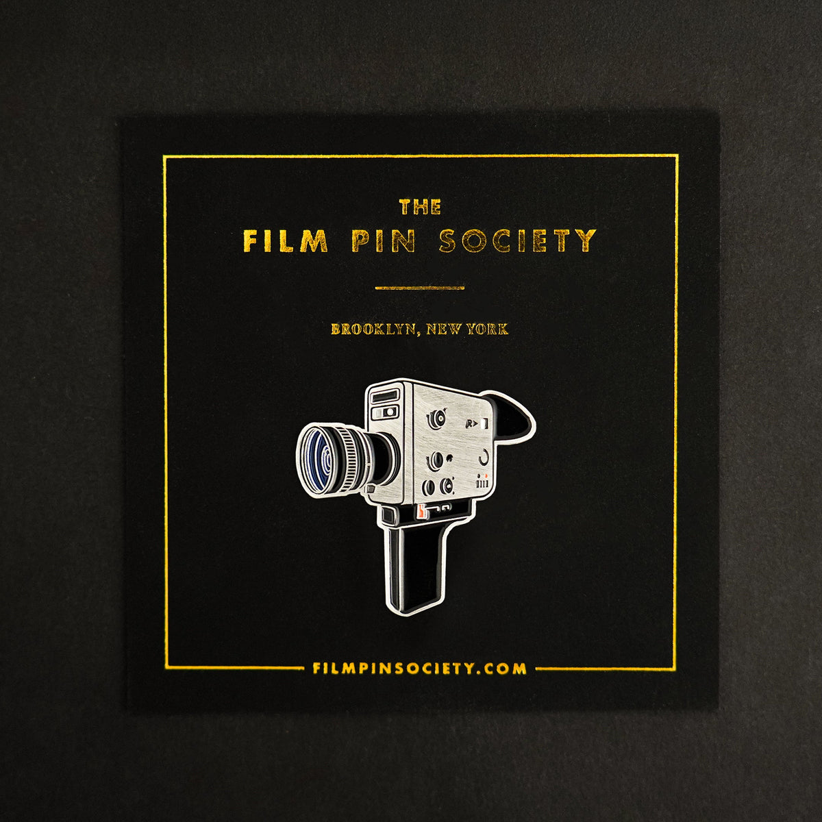 Super 8 Camera Enamel Pin on backing card